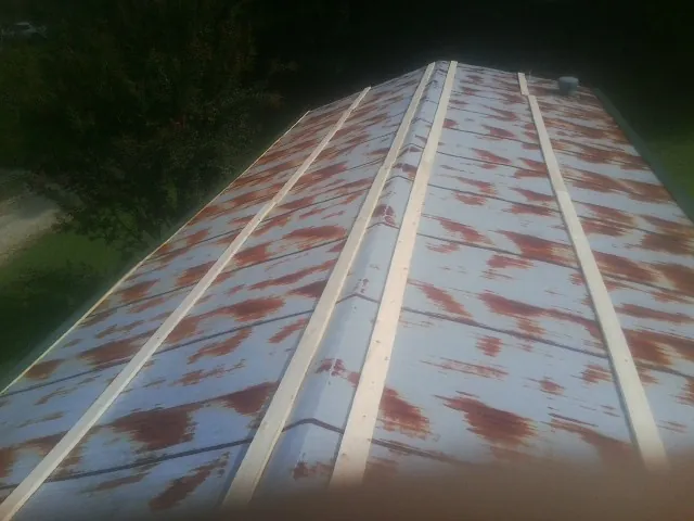 Rusted metal roof panels with new wood purlins before replacement — Storm Damage Roof Repair in Dennis by Roofing Brothers